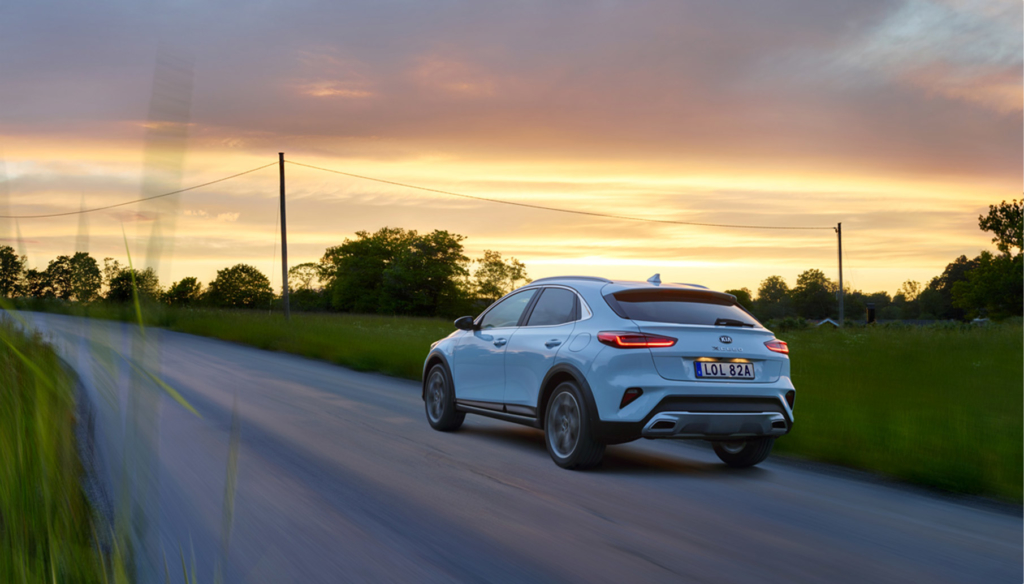 En Kia XCeed Plug-In Hybrid som kör på landsväg under sommarkvällen