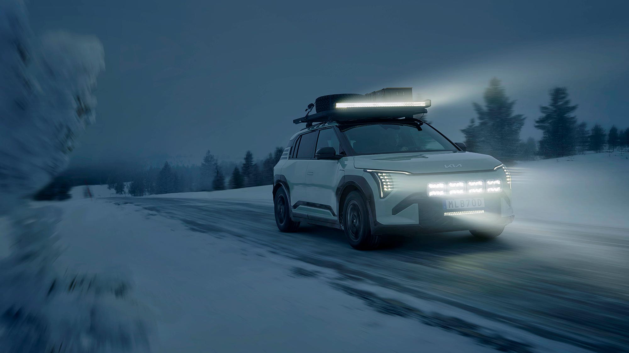 Kia EV3 med tänd LED-ljusramp från Hella på mörk landsväg